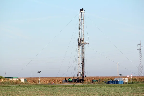 Campo petrolífero com equipamento de perfuração de petróleo terrestre — Fotografia de Stock