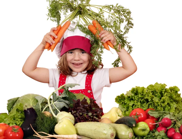 Heureuse petite fille cuisinier avec des carottes et des légumes — Photo