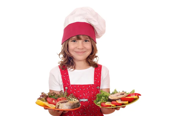 Feliz niña cocinera sosteniendo plato con mariscos de salmón — Foto de Stock