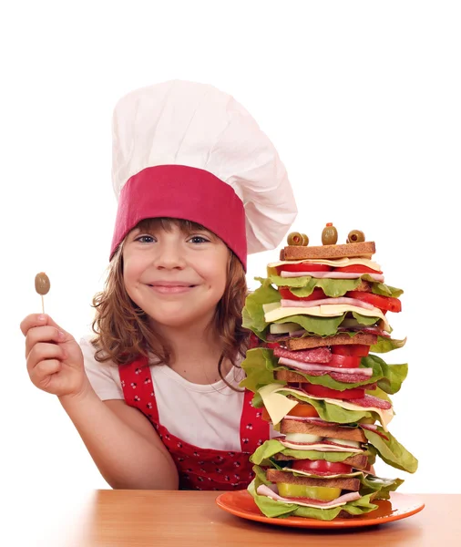 Happy little girl with olive and tall sandwich — Stock Photo, Image