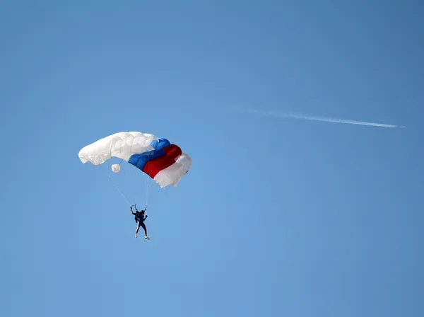 Fallskärmshoppare och flygplan på blå himmel — Stockfoto