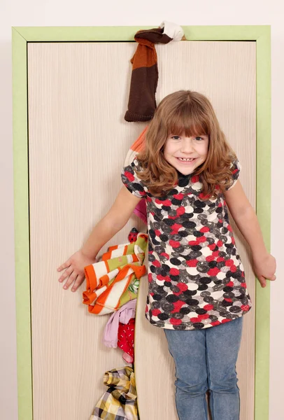 Маленькая девочка пытается закрыть шкаф — стоковое фото