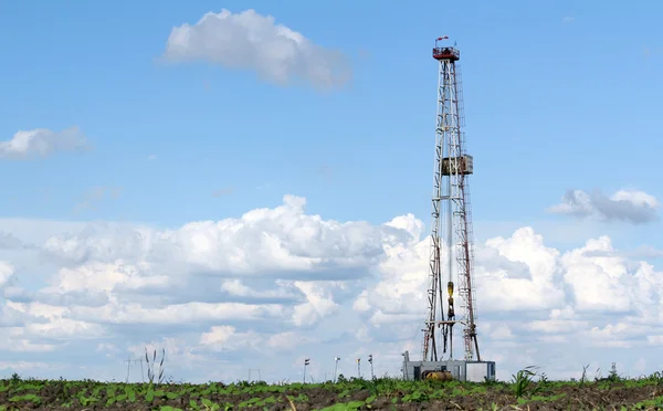 Land oil drilling rig on field landscape — Stock Photo, Image