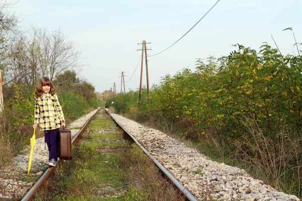 漂亮的小女孩，带着小提箱上铁路 — 图库照片