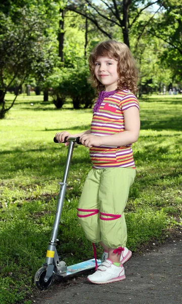 Little girl with scooter in park — Stock Photo, Image