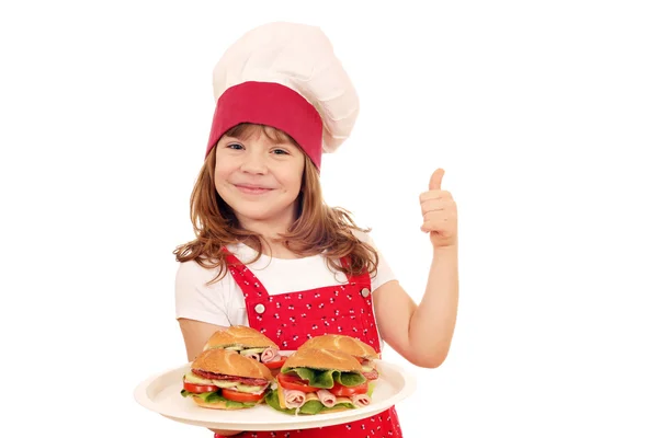 Menina feliz cozinhar com sanduíches e polegar para cima — Fotografia de Stock