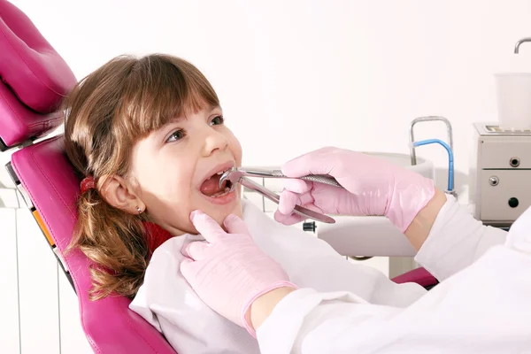 Dentista extraiu o dente menina com alicate — Fotografia de Stock