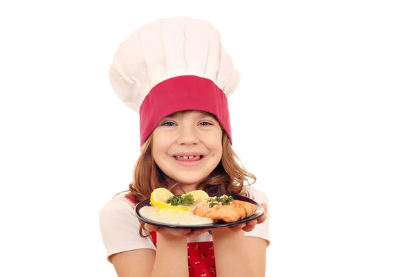 Heureux petite fille cuisinier avec saumon portion de poisson — Photo