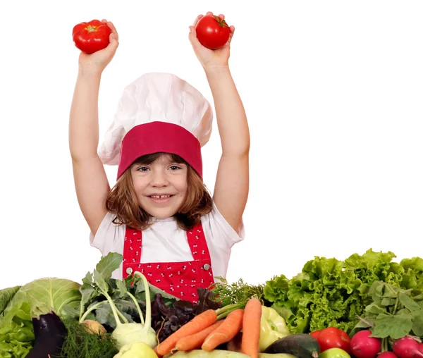 Onnellinen pieni tyttö kokki tomaattien ja vihannesten kanssa — kuvapankkivalokuva