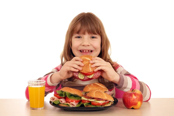 Happy little girl eating sandwich — Stock Photo, Image