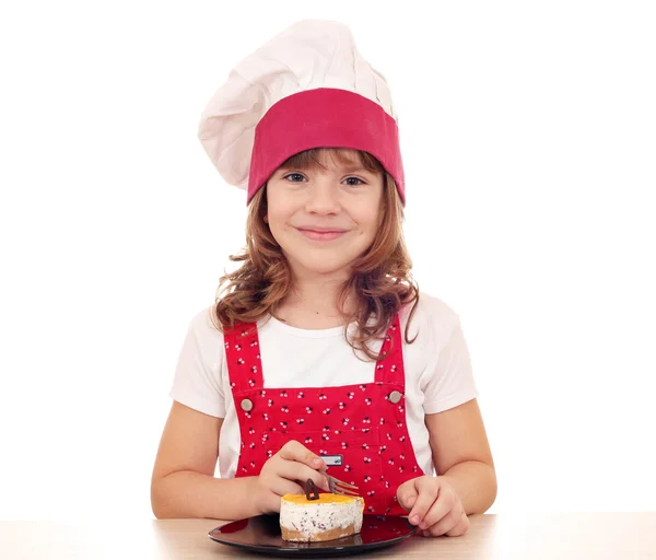 Όμορφο μικρό κορίτσι μάγειρας φάω κέικ — Φωτογραφία Αρχείου