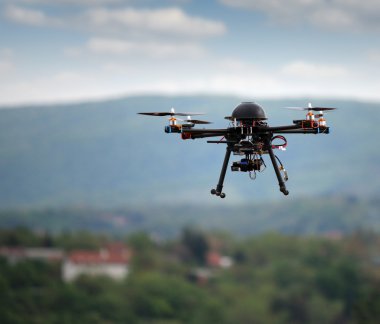 Gökyüzünde kamera olan uçan bir dron. 