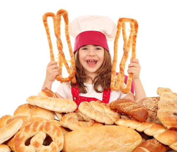 Felice bambina cuoco con pane panino diverso e rotolo — Foto Stock