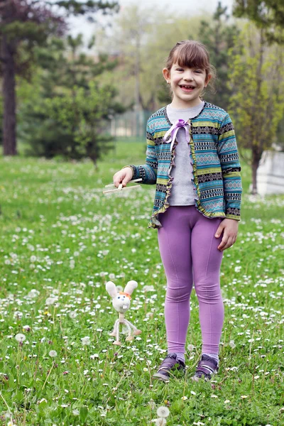 Menina feliz jogar com boneca de marionete de coelho branco — Fotografia de Stock