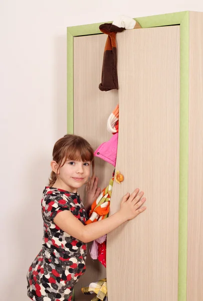 Unhappy little girl with messy closet — Stock Photo, Image