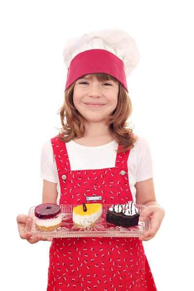 Heureuse petite fille cuisinier avec des gâteaux sucrés — Photo