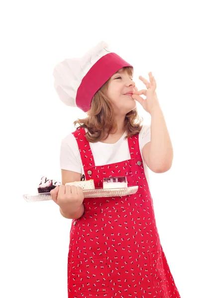 Klein meisje kok met zoete cakes en ok hand teken — Stockfoto