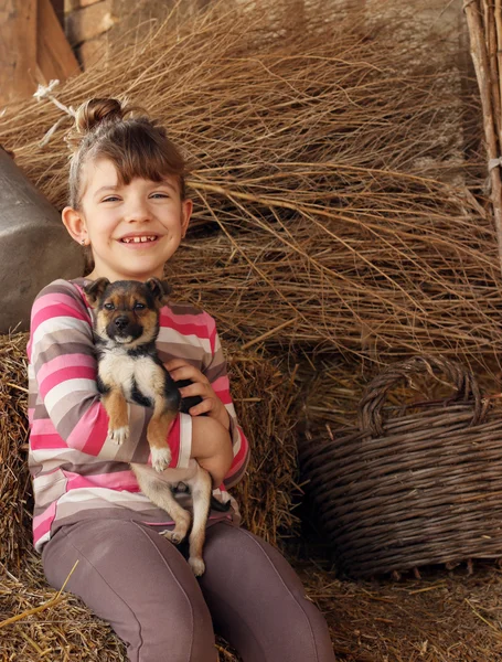 Щаслива маленька дівчинка тримає маленького цуценя — стокове фото