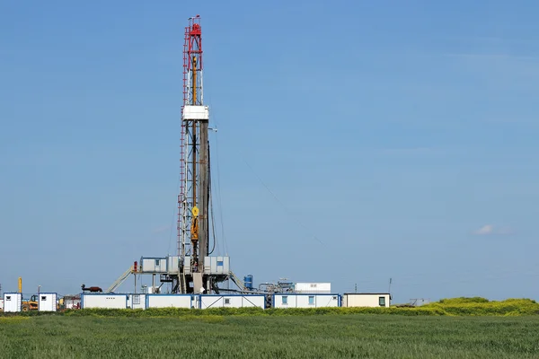 Land oil drilling rig on green field landscape — Stock Photo, Image