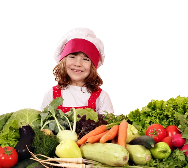 Heureuse petite fille cuisinier avec des légumes — Photo