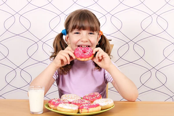 Hambrienta niña comiendo donuts —  Fotos de Stock