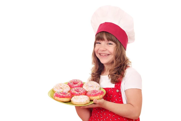 Glückliches kleines Mädchen kocht mit süßen Donuts — Stockfoto