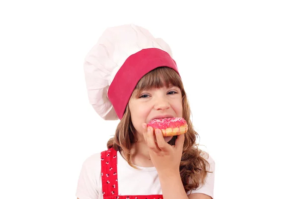 Little girl cook eating sweet donuts — Stock Photo, Image