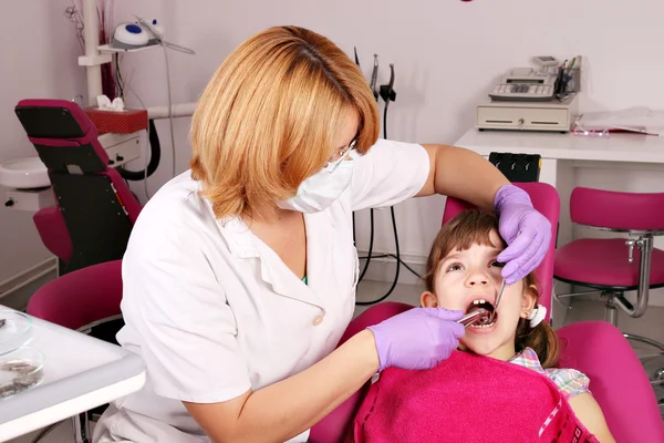 Kobieta dentysty ekstrakcji zęba dziewczynki — Zdjęcie stockowe