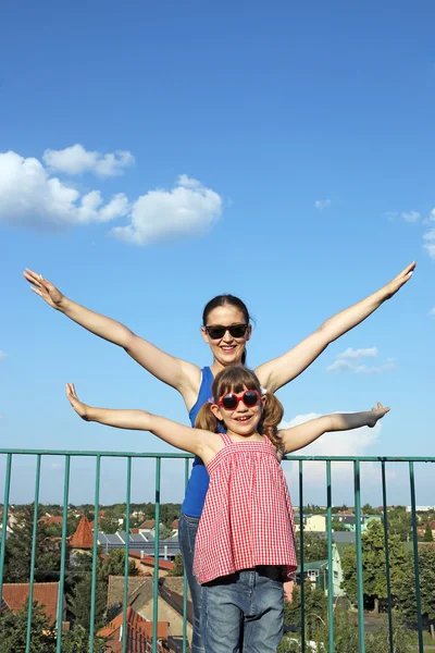 Happy teenage and little girl on building roof — Stock Photo, Image