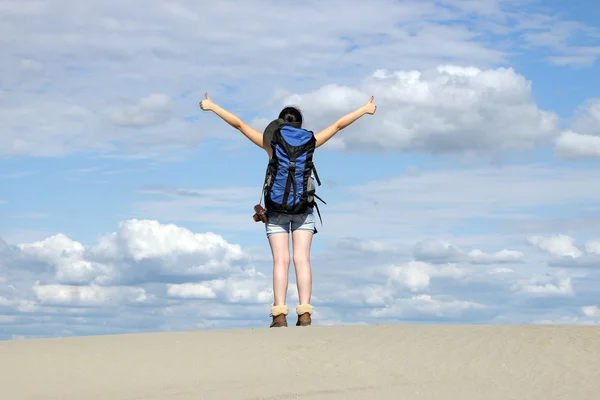 Девушка турист с большими пальцами вверх в пустыне — стоковое фото