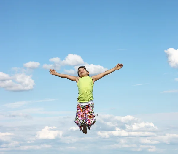 Heureuse petite fille volant dans le ciel — Photo