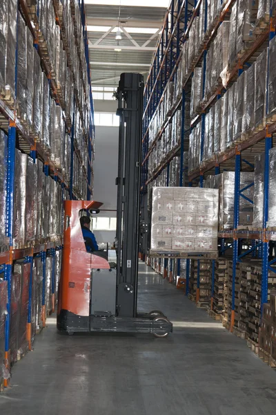 Loader lift a pack inside the modern stock — Stock Photo, Image