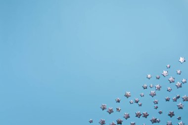 Gümüş yıldızlı Noel kartı kompozisyonu, mavi arka planda Xmas süslemeleri. Kış dekorasyon sınırı