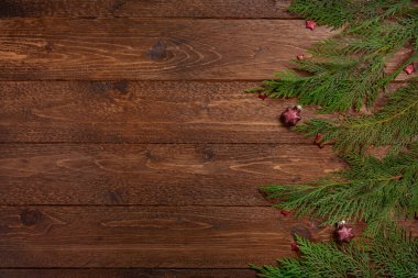 Noel kompozisyonu. Koyu ahşap zemin üzerinde selvi dalları ve kırmızı yıldızlar. Noel, kış konsepti. Düz yatış, üst görünüm.