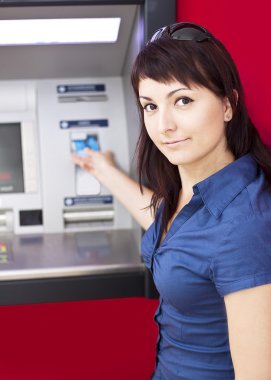 Woman withdrawing money from credit card at ATM clipart