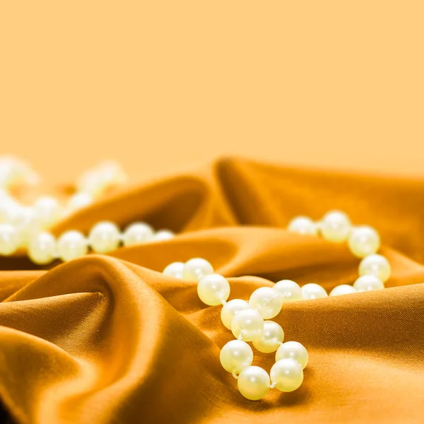 Perlen auf einem seidenen Stoff Hintergrund — Stockfoto