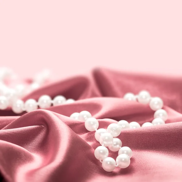 Pearls on a silk fabric background — Stock Photo, Image