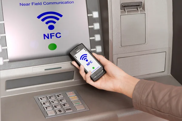 Withdrawing money atm with mobile phone a NFC terminal — Stock Photo, Image