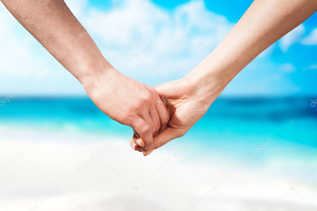Holding hands couple on beach