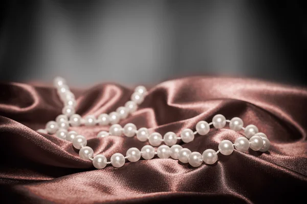 Pearls on a silk fabric background — Stock Photo, Image