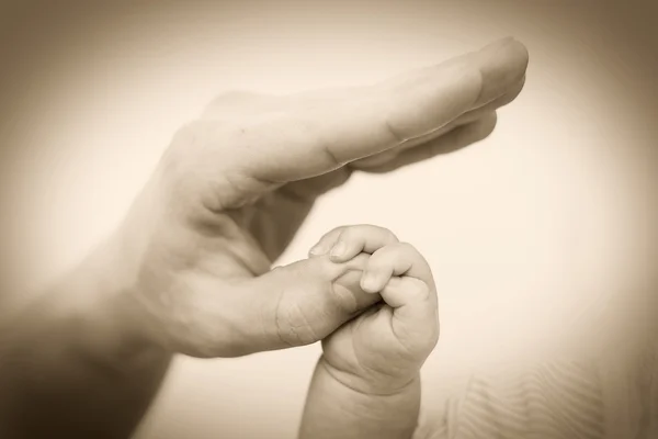 Mano de bebé sosteniendo suavemente el dedo de adulto — Foto de Stock