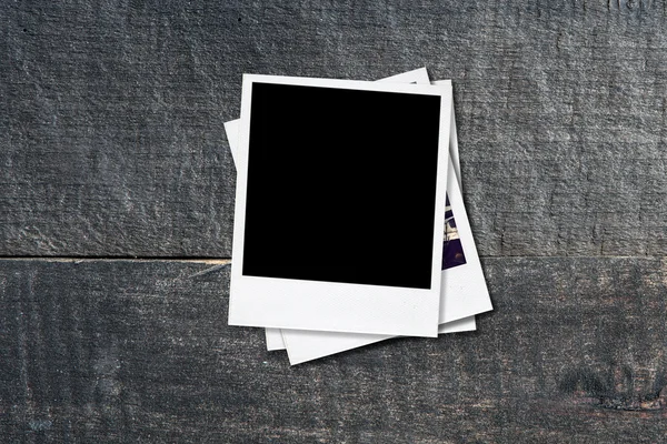 Blank photo frames on old wooden background. — Stock Photo, Image