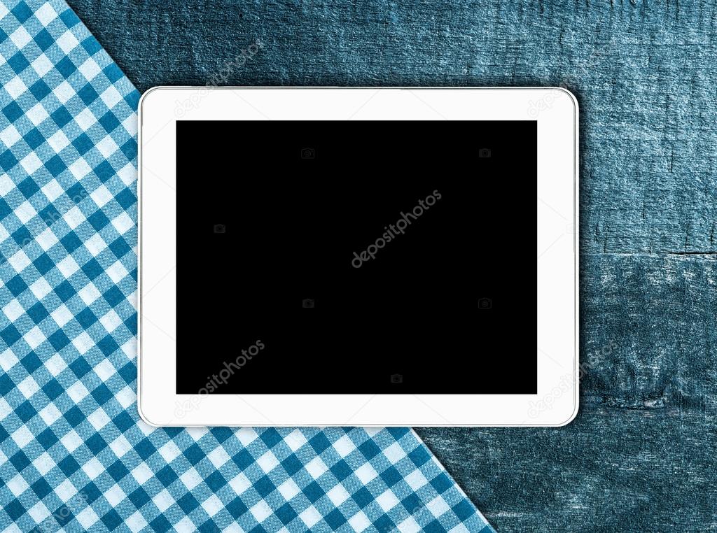 Tablet, tablecloth textile on wooden table