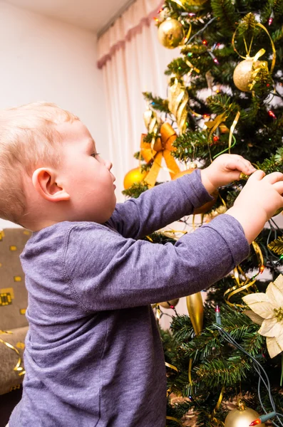 Junge schmückt den Weihnachtsbaum — Stockfoto