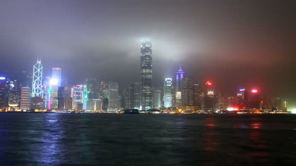 Wolkenkratzer in Hongkong-Stadt bei Nacht vom Victoria-Hafen aus gesehen — Stockvideo