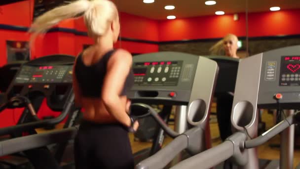 Bela mulher esportiva está se exercitando no centro de fitness — Vídeo de Stock