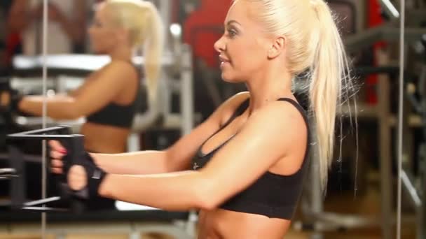 Hermosa mujer deportiva está haciendo ejercicio en el centro de gimnasia — Vídeos de Stock