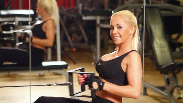 Hermosa mujer deportiva está haciendo ejercicio en el centro de gimnasia — Vídeos de Stock