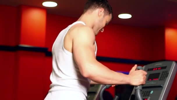 Knappe sportieve man is de uitoefening van in gym centrum — Stockvideo