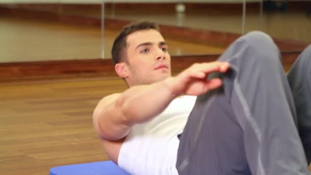 Przystojny mężczyzna sportowy jest ćwiczenia w siłowni centrum — Wideo stockowe